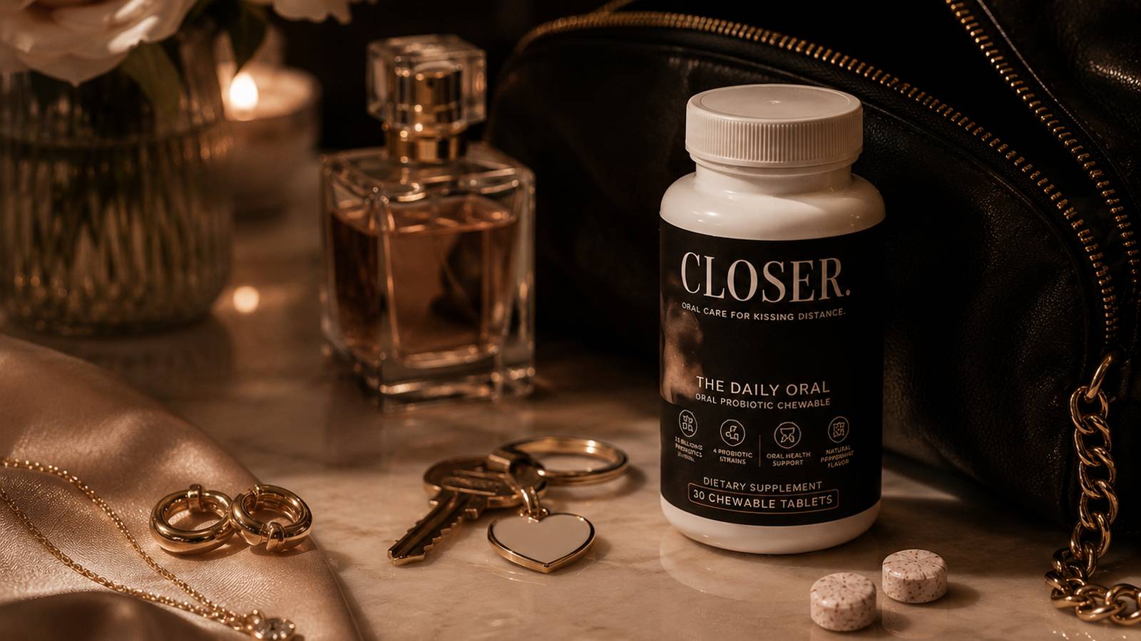 CLOSER. The Daily Oral on a marble vanity next to perfume, keys, jewelry and a leather bag
